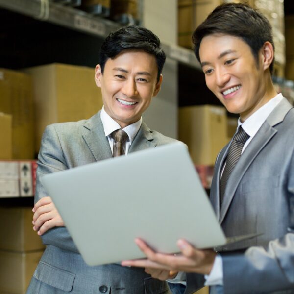Business partners with laptop in logistic warehouse