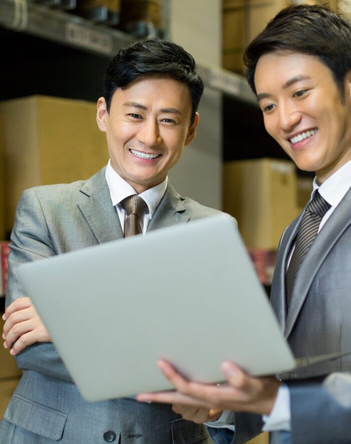 Business partners with laptop in logistic warehouse
