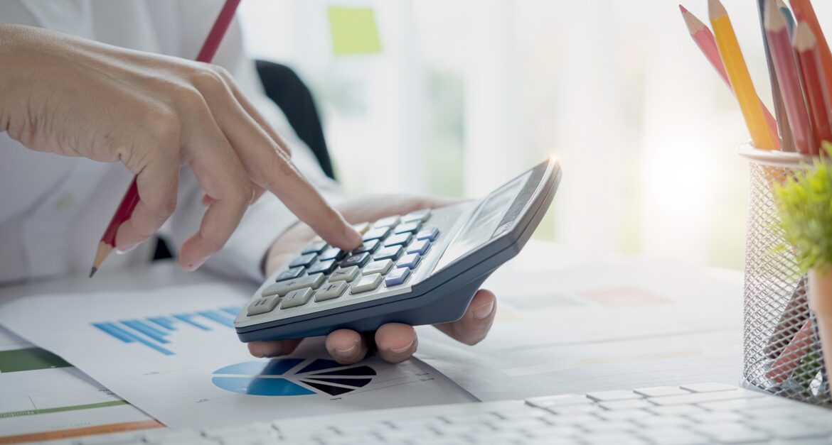 Close up view of bookkeeper or financial inspector hands making report, calculating or checking