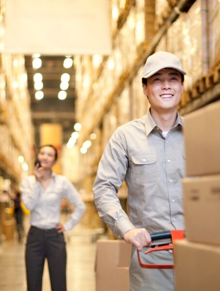 Male Chinese warehouse with Chinese businesswoman in the background