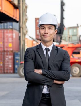 Portrait of engineer worker of factory technician with Chinese style man stand in cargo workplace