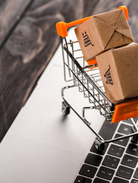 toy boxes in small shopping cart on laptop, e-commerce concept